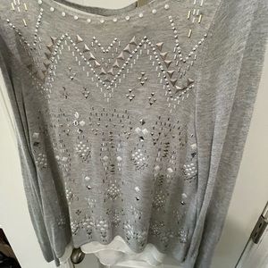 Gray top with the white sheer in the back front has gold and silver pieces on it